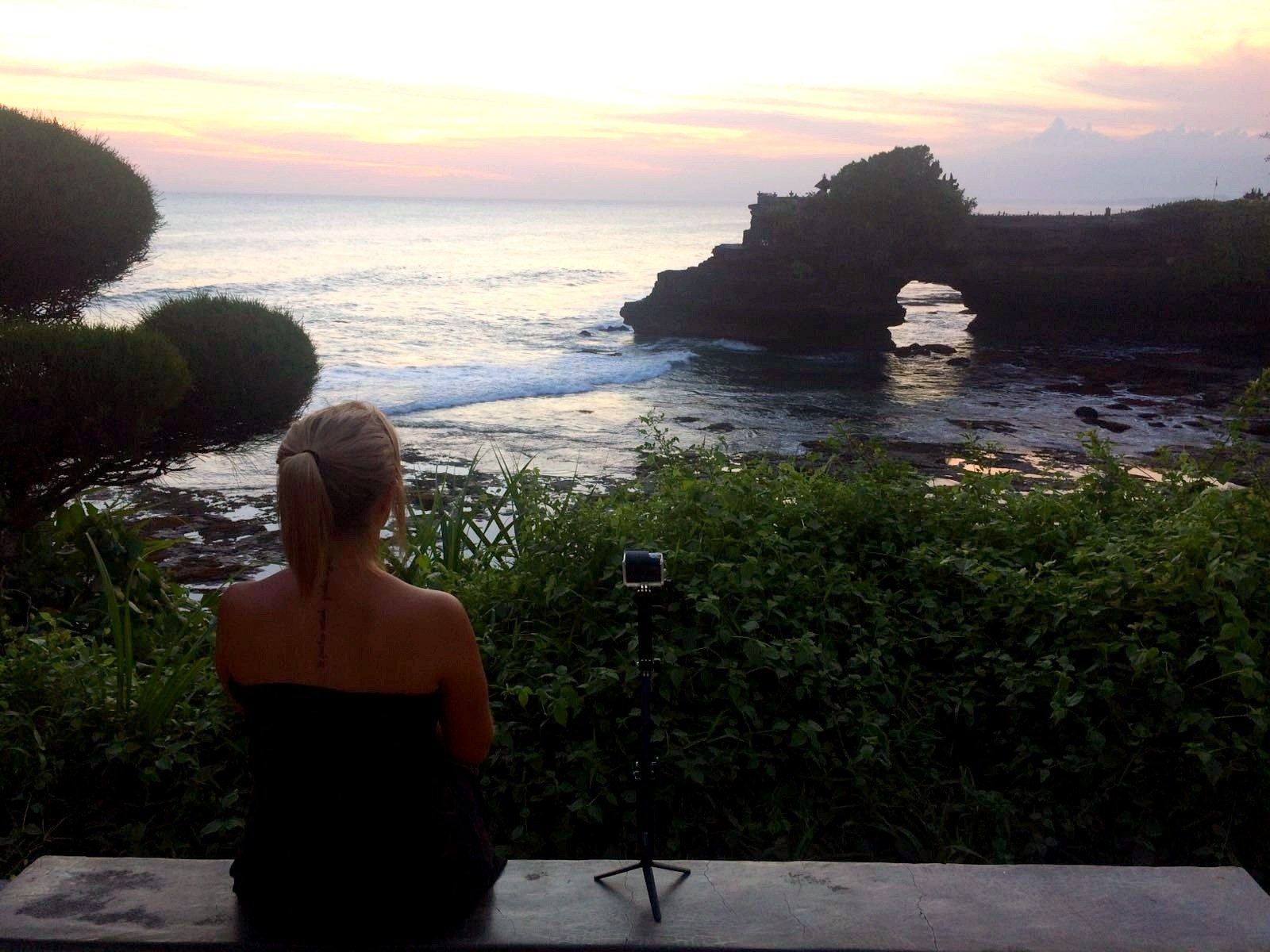 Sonia observa el atardecer en Tanah Lot junto a su cámara
